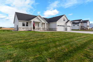 Modern inspired farmhouse with board and batten siding, a porch, stone siding, a front lawn, and driveway