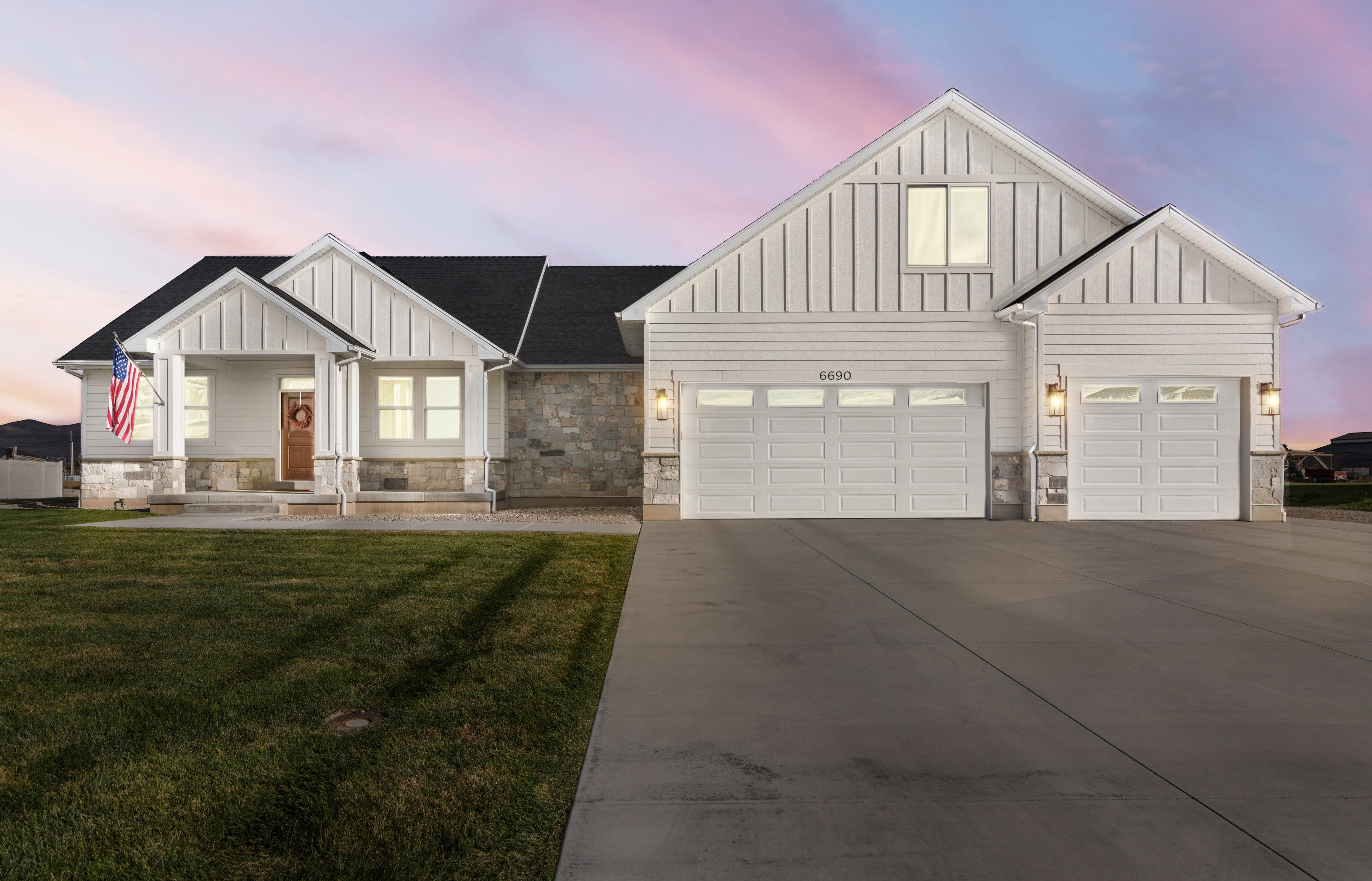 Modern inspired farmhouse featuring board and batten siding, a porch, concrete driveway, and a yard