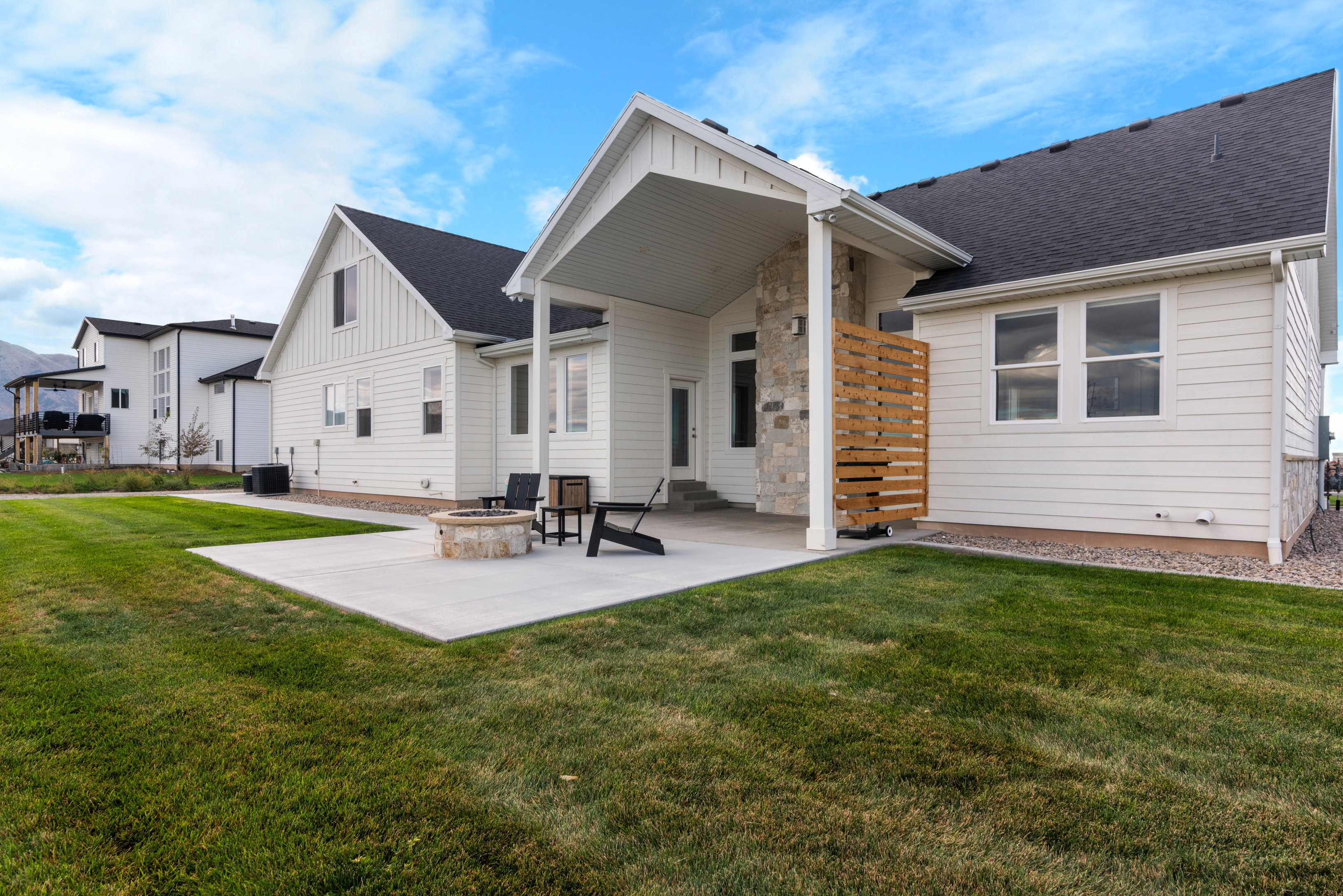 Back of property with a patio, a yard, and board and batten siding
