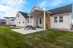Back of property with a patio, a yard, and board and batten siding