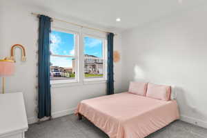 Carpeted bedroom with baseboards and recessed lighting