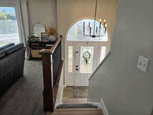 Foyer entrance with plenty of natural light, a chandelier, and wood finished floors