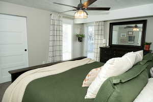 Bedroom with a textured ceiling and a ceiling fan