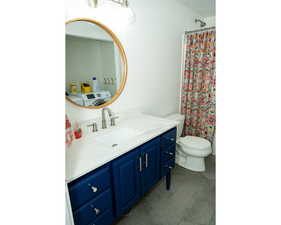 Full bath featuring vanity, washer / clothes dryer, dark tile patterned floors, and curtained shower