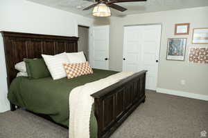 Bedroom with carpet flooring, a textured ceiling, a closet, and a ceiling fan