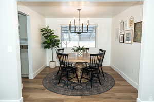 Dining room featuring dark wood-type flooring and a chandelier