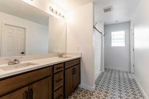 Primary bathroom featuring double vanity and custom tile.
