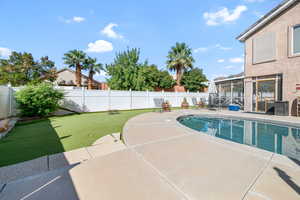 View of pool featuring a sunroom, a fenced backyard, and a patio area