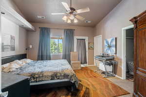 Bedroom featuring carpet flooring, ceiling fan, and a textured ceiling