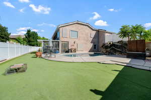 Back of property featuring a patio area, a fenced backyard, a sunroom, and stucco siding