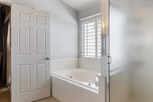 Full bath with a stall shower, a bath, and light tile patterned floors