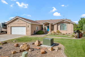Single story home with a front lawn, a garage, stucco siding, and concrete driveway