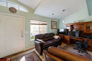 Office featuring lofted ceiling, wood finished floors, and a textured ceiling