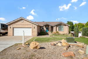 Ranch-style house featuring concrete driveway, an attached garage, a front yard, and stucco siding