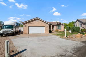 Single story home with stucco siding, driveway, and an attached garage