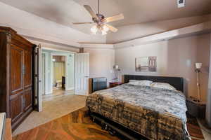 Carpeted bedroom featuring ceiling fan and vaulted ceiling