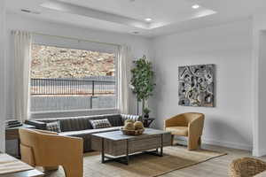 Sitting room featuring a tray ceiling, wood finished floors, and recessed lighting