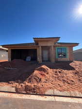 View of front facade featuring a patio area and a garage