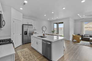 Kitchen featuring stainless steel appliances, dark wood-style flooring, open floor plan, white cabinets, and recessed lighting