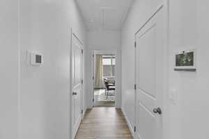 Hallway with light wood-type flooring and baseboards
