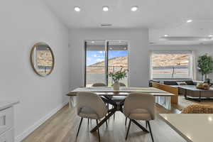 Dining space with light wood finished floors, plenty of natural light, and recessed lighting