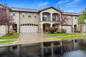 Mediterranean / spanish-style home featuring stucco siding, a balcony, concrete driveway, and stone siding