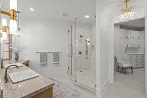 Full bathroom featuring a chandelier, a stall shower, vanity, and recessed lighting