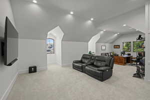 Home theater room featuring lofted ceiling, light colored carpet, recessed lighting, and plenty of natural light