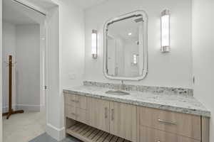 Full bath featuring vanity and baseboards