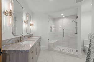 Bathroom with double vanity, a stall shower, and recessed lighting