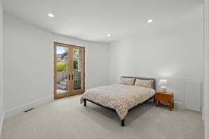 Bedroom featuring access to outside, recessed lighting, light carpet, and french doors