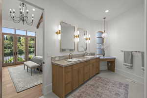 Bathroom featuring double vanity, recessed lighting, a chandelier, and french doors