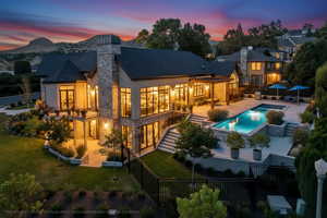 Back of house featuring a fenced backyard, a patio area, a chimney, stucco siding, and stone siding