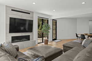 Living area featuring light wood-type flooring, recessed lighting, and a fireplace