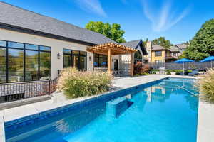 View of swimming pool featuring a patio area, a pergola, and a residential view