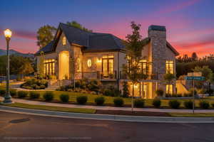 French country style house featuring stone siding, stairway, stucco siding, a chimney, and a balcony