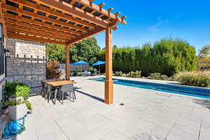 Swimming pool with a pergola, a patio area, and outdoor dining area