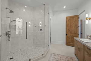 Full bath with a stall shower, vanity, light tile patterned floors, and recessed lighting