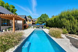 View of swimming pool featuring a patio, a pergola, and a residential view