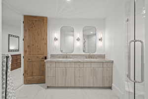 Full bathroom with double vanity, a stall shower, and recessed lighting
