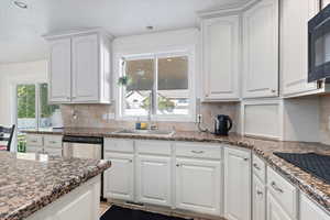 Kitchen featuring backsplash, white cabinetry, black appliances, dark stone counters, and recessed lighting