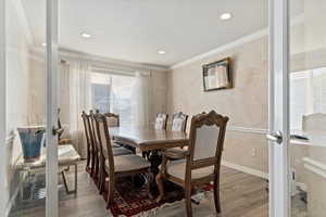 Dining area featuring ornamental molding, french doors, light wood finished floors, and recessed lighting