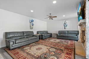 Living room featuring a ceiling fan, light wood-style flooring, and recessed lighting