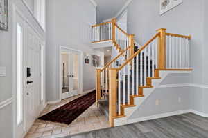Entryway featuring french doors, a high ceiling, wood finished floors, and crown molding