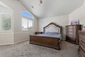 Carpeted bedroom with lofted ceiling and ceiling fan