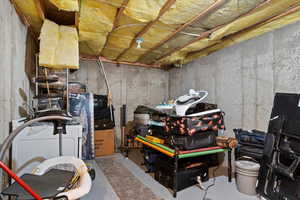 Unfinished below grade area featuring washer / dryer