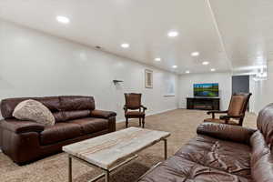 Carpeted living room featuring recessed lighting and a glass covered fireplace