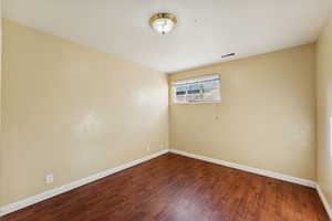Unfurnished room featuring baseboards and wood finished floors