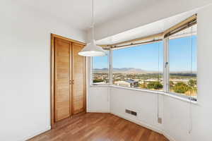 Unfurnished dining area featuring a mountain view and light wood-type flooring