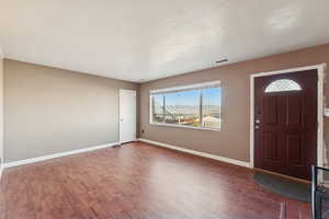 Entrance foyer with wood finished floors, a textured ceiling, and a mountain view